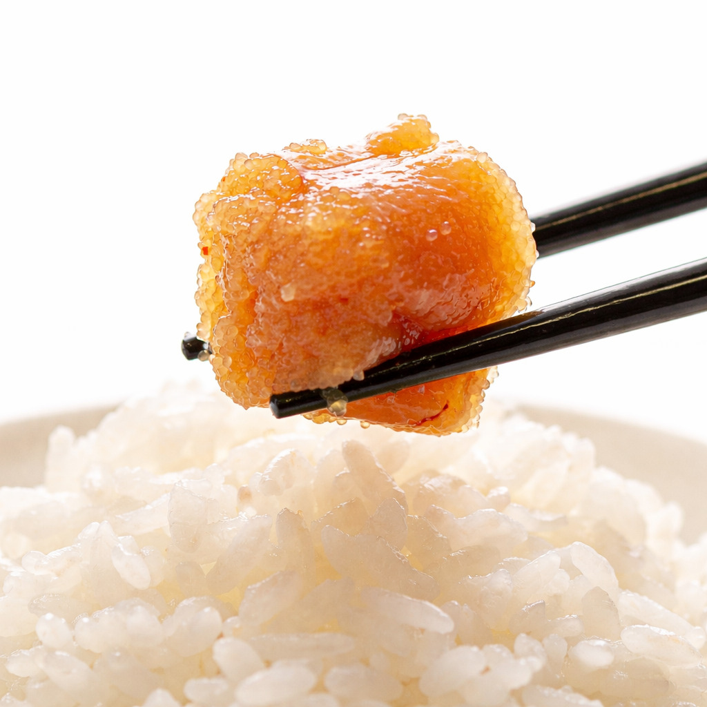 ご飯の上で箸に持ち上げられた食品添加物無添加の辛子明太子きわめんたい